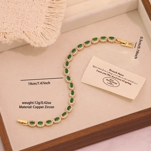 Detailed macro view of an emerald green zircon copper bracelet on a beige velvet tray