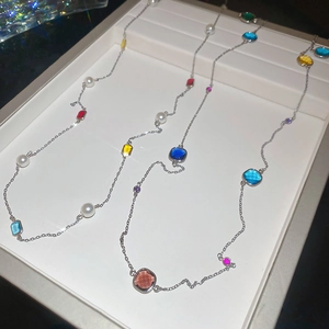 Detail of multi-color gemstone and pearl layered necklace on professional jewelry display