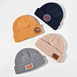 Flat lay of warm acrylic winter beanies in navy, mustard, beige and grey colors