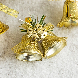 Golden Christmas bell ornaments with glittery bow and pine needles for holiday tree decor