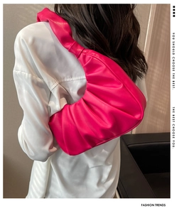 Detailed view of the vibrant rose red pleated shoulder bag in soft PU leather texture