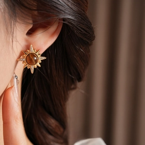 Vintage starburst stud earrings with tiger eye stone and zircons on female model