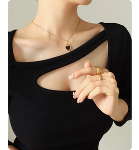 Détail d'un collier pendentif cœur doré 18 carats avec incrustation noire sur un mannequin