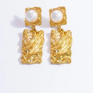 Detailed view of 18K gold plated pearl earrings with diamond accents on a white backdrop