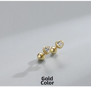 Detail showing gold heart earrings with white zircon and secure screw-back ball closures