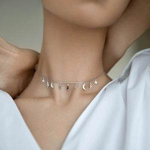 Close-up of S925 sterling silver necklace featuring star, lightning, and moon pendants