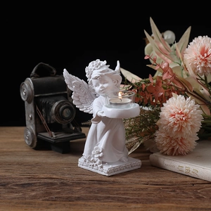 European style white angel candle holder with glass cup on rustic wooden table background