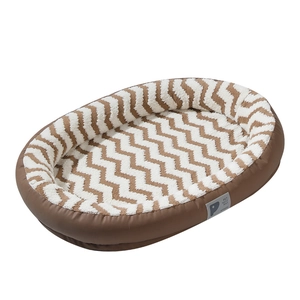 Oval pet bed with faux leather exterior and soft plush wave patterned inner cushion
