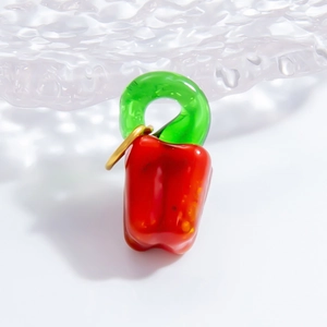 Detailed view of a red pepper-shaped glass pendant with a green stem and golden ring