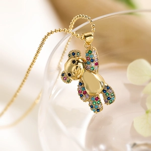 Vue détaillée du pendentif ourson doré serti de zircons étincelants multicolores