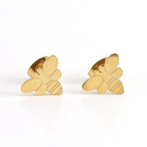 Minimalist gold bee-shaped stainless steel stud earrings on a white reflective surface
