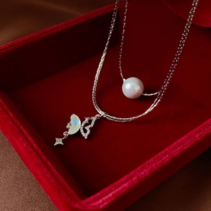 Detail of silver double-layered necklace with pearl and butterfly in red velvet box