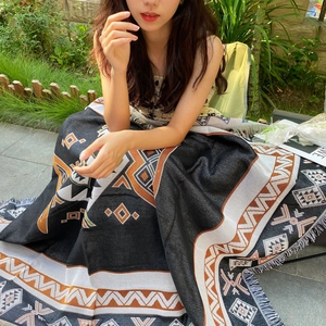 Close-up of geometric pattern blanket with fringes used as a leg wrap outdoors