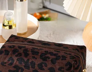 Detailed view of leopard print cosmetic bag with gold zipper in a cozy room setting