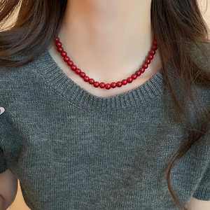 Detail of red glass beaded necklace on neck showing glossy 6mm-8mm round beads