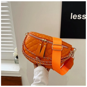 Detail of vibrant orange quilted waist bag featuring gold chain and wide nylon strap
