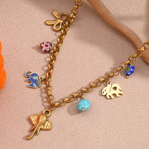 Macro detail of 18K gold-plated necklace with colorful elephant and heart charms