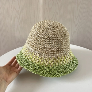 Dettaglio del cappello cloche in paglia intrecciata a mano con sfumatura crema e verde acceso