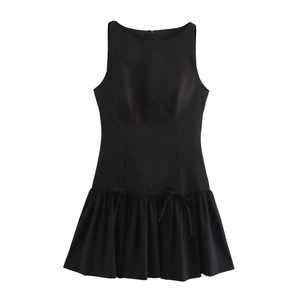 Detail of a black sleeveless round neck dress featuring bow accents and a pleated hemline