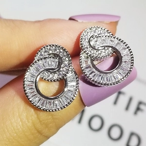 Close-up of sparkling silver interlocking hoop earrings with micro-set zircon stones