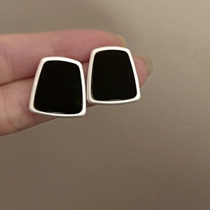 Detail view of vintage geometric resin stud earrings with black finish and silver trim