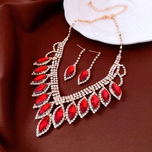 Close-up of elegant red drop pendant necklace and earrings set on velvet background