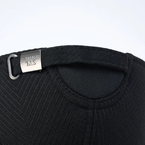 Macro detail of black herringbone wool baseball cap with engraved metal buckle