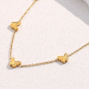 Detailansicht der 18K vergoldeten Schmetterlingsanhänger an einer Edelstahlkette