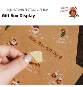 Detail showing hand peeling a kraft paper Christmas tree gift tag with festive motifs