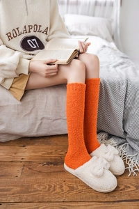 Detail of warm orange coral fleece knee-high socks showing soft plush texture for winter