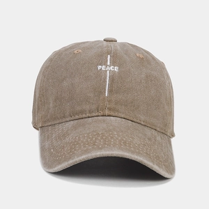 Detailed close-up of white PEACE embroidery on vintage washed brown cotton baseball cap