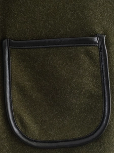 Detailed macro view of olive green woolen coat pocket with black leather piping trim