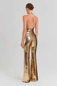 Detail view of the back showing a gold sequin jumpsuit with halter neck and hidden zipper