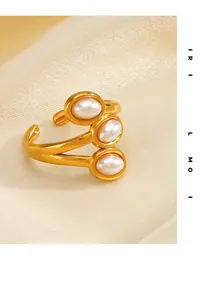 Detail of gold-plated ring featuring three vertically aligned pearls on silk fabric