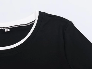Detail of black ribbed knit T-shirt featuring a white contrast neckline and size S label