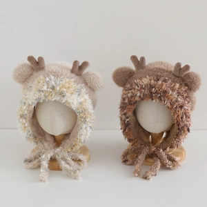 Detailed view of plush reindeer hats with 3D antlers and woven chin ties for kids