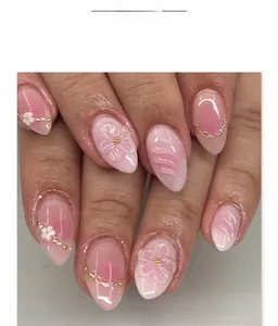 Macro detail of almond press-on nails with 3D floral accents and pink gradient
