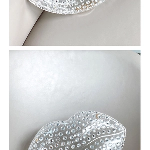 Close-up of sparkling rhinestones on a transparent lip-shaped evening clutch bag