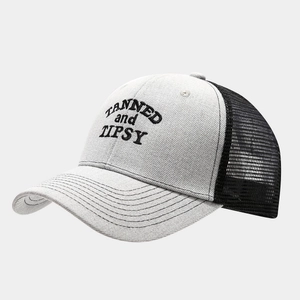 Close-up of TANNED and TIPSY embroidery and mesh texture on the trucker hat