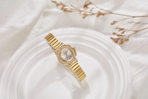 Vue détaillée du cadran en forme de fleur d'une montre dorée pour femme avec quartz