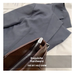 Detailed close-up of premium silver zipper and hardware on a brown leather tote bag
