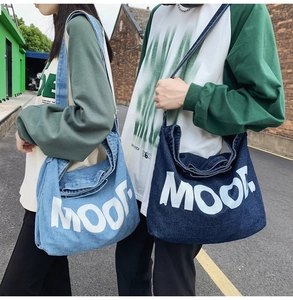 Outdoor shot showing large capacity denim crossbody bags with MOOD print on models