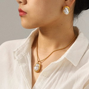 Elegant French baroque pearl necklace and earrings set on model with golden finish