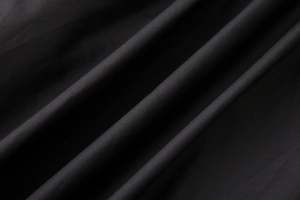 Détail macro de la texture du tissu en coton noir avec un drapé diagonal fluide