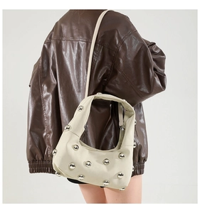 Detailed shoulder view of off-white crescent bag with silver stud rivets and a sleek strap
