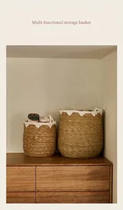 Détail de deux paniers de rangement tressés avec motifs de vagues blanches sur bois