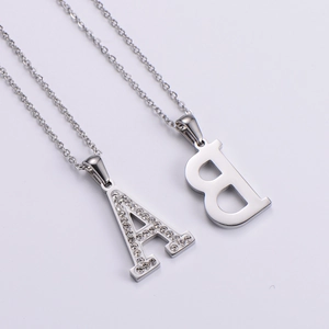 Close-up of silver letter A and B pendants with inlaid rhinestones and metal finish