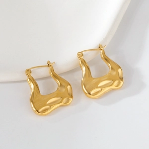 Détails macro des boucles d'oreilles croissant en U dorées avec fini métal poli