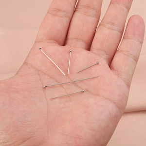 Hand holding silver stainless steel ball head pins for DIY jewelry making and crafting