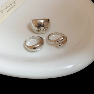 Three-piece silver polished irregular ring set in white ceramic bowl with dark contrast